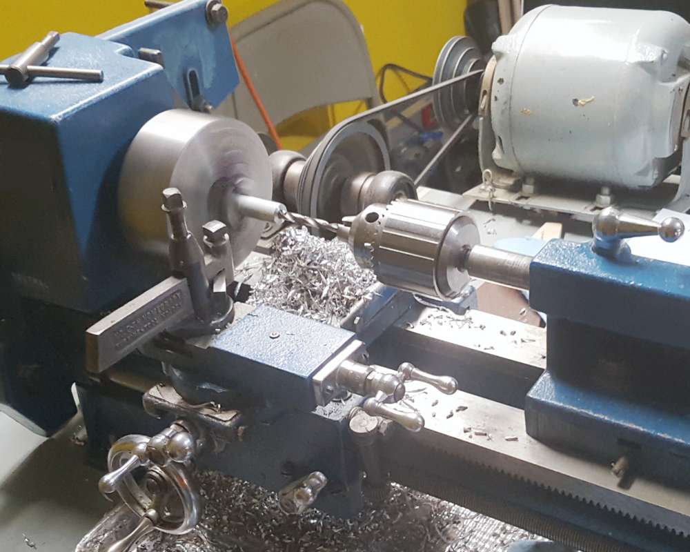 benchtop metal lathe maching an aluminum bar to make a vinyl record crate